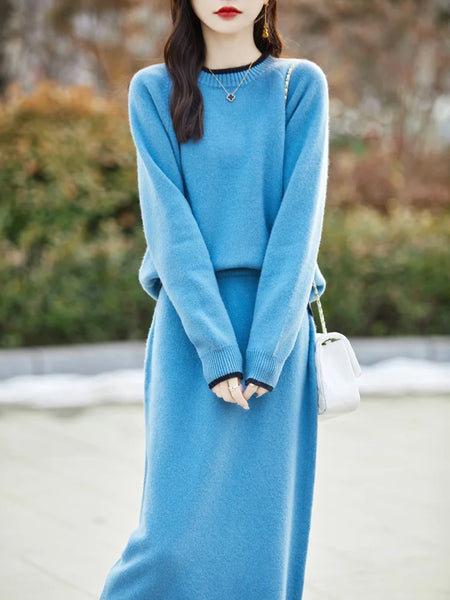 Woman wearing a long blue sweater with a blurred outdoor background