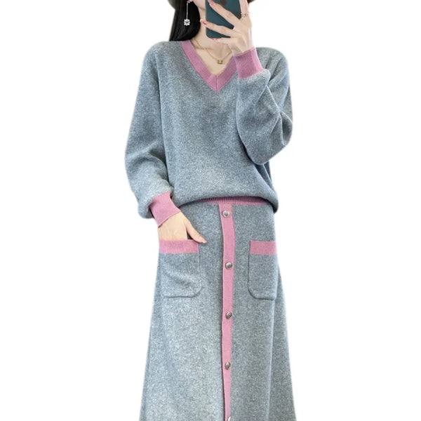 Gray sweater and skirt set with pink accents worn by a person on a white background