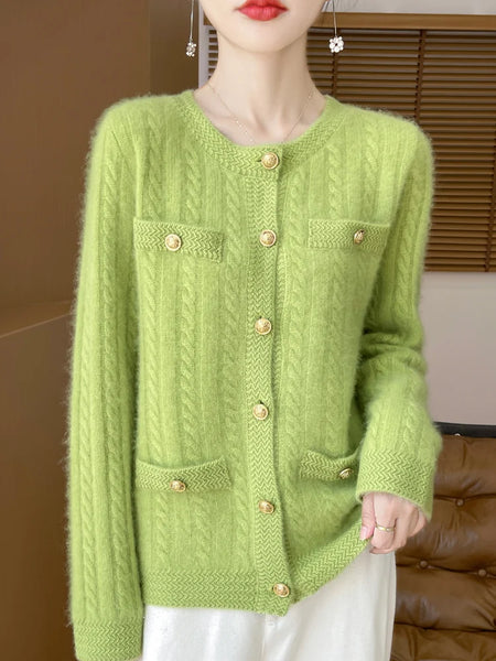 Person wearing a green knitted cardigan with gold buttons against a neutral background