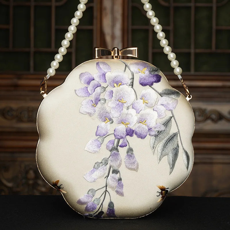 Handbag with floral design and pearl handle on a dark background