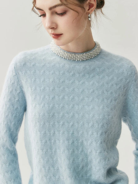 Light blue cable knit sweater worn by a person with a neutral background