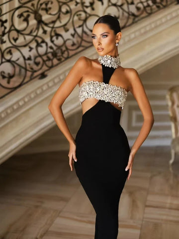 Woman wearing a black evening gown with a beaded top in an elegant interior setting