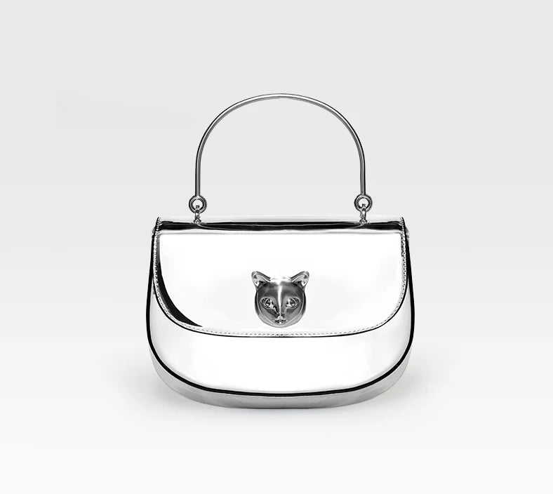 Silver handbag with a cat face emblem on a white background