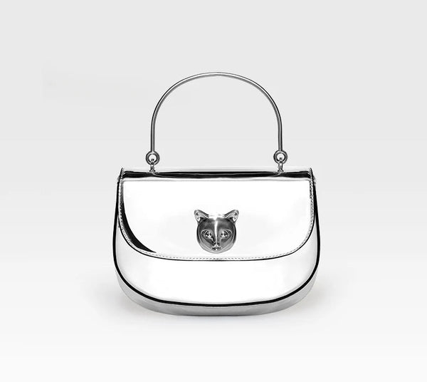 Silver handbag with a cat face emblem on a white background