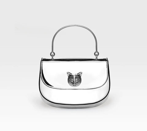 Silver handbag with a cat face emblem on a white background