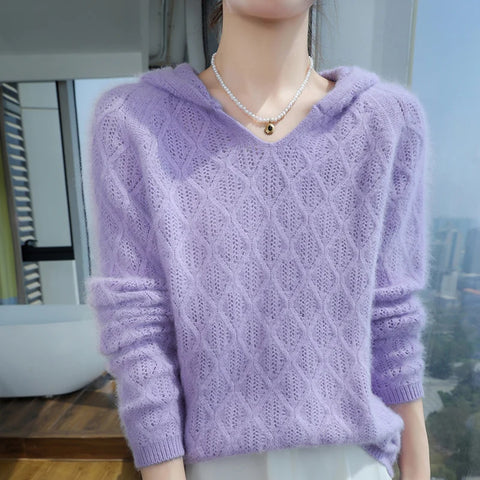 Person wearing a purple knitted sweater with a blurred indoor background