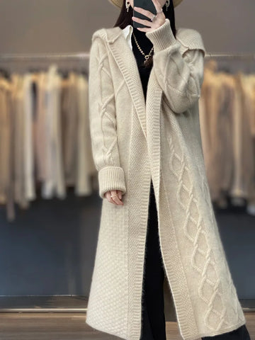 Person wearing a long beige knitted cardigan in a clothing store.
