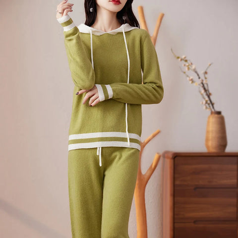 Woman wearing a green sweater and pants set with a blurred background