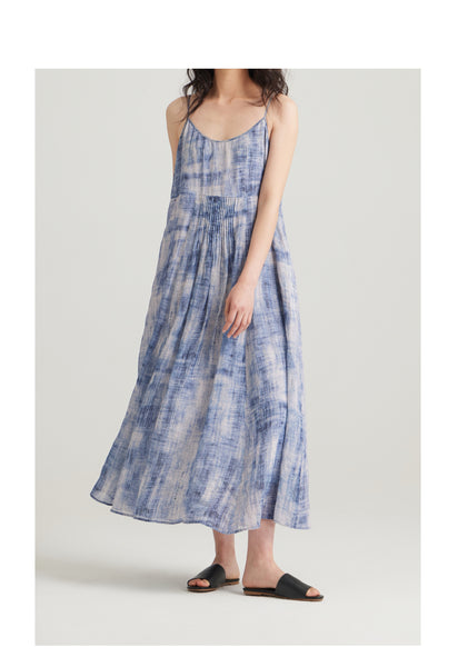 Woman wearing a blue tie-dye dress on a white background